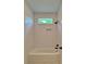 Cozy tub/shower combo with clean white tiling, a built-in niche, and window that offers natural light at 300 Eminence Peak, Rydal, GA 30171