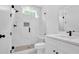 Bathroom with large marble tile shower featuring bench and shower niche, plus a white vanity with black fixtures at 300 Eminence Peak, Rydal, GA 30171