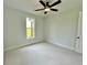 Light-filled bedroom with plush carpet, ceiling fan, and a view of the home's exterior at 300 Eminence Peak, Rydal, GA 30171