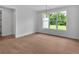 Bright dining room with hardwood floors, a modern chandelier, and a large window with a view of the outdoors at 300 Eminence Peak, Rydal, GA 30171