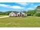 Expansive lawn showcases this modern farmhouse's elegant facade under a bright sky at 300 Eminence Peak, Rydal, GA 30171