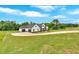 Lush front yard shows the driveway and garage attached to this modern farmhouse at 300 Eminence Peak, Rydal, GA 30171