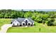 A beautiful new construction home is framed by mature trees and a lush green lawn at 300 Eminence Peak, Rydal, GA 30171