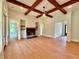 Open living area with a fireplace and beams on the ceiling at 300 Eminence Peak, Rydal, GA 30171