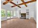 Spacious living room with stone fireplace, beamed ceilings, and French doors to the patio at 300 Eminence Peak, Rydal, GA 30171