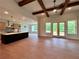 Open floor plan with a kitchen island, living room with beams, and lots of windows and light at 300 Eminence Peak, Rydal, GA 30171