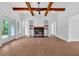 Bright living room featuring hardwood floors, stone fireplace, and beamed ceilings at 300 Eminence Peak, Rydal, GA 30171