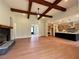 Open concept with a living room with beams and a fireplace plus the kitchen at 300 Eminence Peak, Rydal, GA 30171