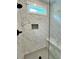 Elegant marble-tiled shower with rainfall shower-head, niche, and bench for a spa-like experience at 300 Eminence Peak, Rydal, GA 30171