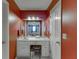 Well-lit bathroom with a vanity, mirror, and colorful wallpaper, located adjacent to the bedroom at 4092 Deerbrook Sw Way, Lilburn, GA 30047