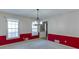 Bright dining room with a statement chandelier, white upper walls, red lower walls, and natural light at 4092 Deerbrook Sw Way, Lilburn, GA 30047