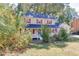 Charming two-story home with red shutters, a white porch, and mature trees at 4092 Deerbrook Sw Way, Lilburn, GA 30047