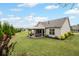 Backyard view featuring a cozy patio, lush greenery, and the home's exterior at 5775 Stellata Cir, Cumming, GA 30028