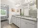 Bathroom with granite countertops, and sinks, framed mirrors, and a doorway view of the main bedroom at 5775 Stellata Cir, Cumming, GA 30028