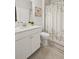 Clean bathroom featuring a white vanity, a flower picture, and a decorative shower curtain at 5775 Stellata Cir, Cumming, GA 30028