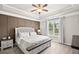 Beautiful bedroom featuring decorative wall trim, tray ceiling, ceiling fan, and large window with natural light at 5775 Stellata Cir, Cumming, GA 30028