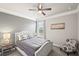 Cozy bedroom featuring a decorative accent wall, a ceiling fan, a comfy chair, and a large window at 5775 Stellata Cir, Cumming, GA 30028