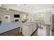 Open kitchen with granite island, appliances, and seamless flow to the living room at 5775 Stellata Cir, Cumming, GA 30028