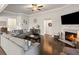 Spacious living room with a fireplace, ceiling fan, and modern furniture at 5775 Stellata Cir, Cumming, GA 30028