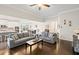 Open-concept living room showcasing hardwood floors and seamless flow to dining area and kitchen at 5775 Stellata Cir, Cumming, GA 30028