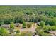 A high angle shot showcasing a lovely home with manicured lawns, surrounded by dense trees and other residences at 630 Silverberry Ln, Sugar Hill, GA 30518