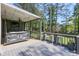 Charming covered back deck with a comfortable swing, complemented by barstools and a view of the serene backyard at 630 Silverberry Ln, Sugar Hill, GA 30518