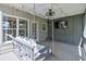 Relaxing covered back deck featuring a hanging swing, ceiling fan, and a mounted TV, creating an ideal outdoor retreat at 630 Silverberry Ln, Sugar Hill, GA 30518