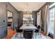 Formal dining room with modern chandelier, wainscoting, and dark gray walls provides an intimate atmosphere at 630 Silverberry Ln, Sugar Hill, GA 30518