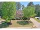 Traditional brick home with manicured landscaping and mature trees on a well-maintained front lawn at 630 Silverberry Ln, Sugar Hill, GA 30518