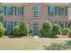 Close up of the home's brick front facade featuring the gray front door and manicured landscaping at 630 Silverberry Ln, Sugar Hill, GA 30518