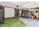 Garage features a golf simulator with putting green, and organized storage, a sports enthusiast's dream at 630 Silverberry Ln, Sugar Hill, GA 30518