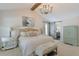 Airy bedroom with elegant chandelier, seating, barn door to bathroom, and soothing natural light at 630 Silverberry Ln, Sugar Hill, GA 30518