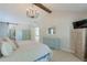 Vaulted main bedroom with modern chandelier, wood beam, barn door to bathroom, and soothing color palette at 630 Silverberry Ln, Sugar Hill, GA 30518