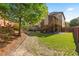 Beautiful backyard with lush grass, colorful flowers, and stairs leading to an elevated screened porch at 1212 Overlook Lake Dr, Dacula, GA 30019