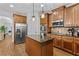 Open kitchen with stainless steel fridge, granite countertops, and a central island at 1212 Overlook Lake Dr, Dacula, GA 30019