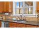 A well-appointed kitchen features a double sink with granite countertops and wood cabinets at 1212 Overlook Lake Dr, Dacula, GA 30019