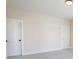 Neutral bedroom featuring carpeted floors, white doors, and simple lighting at 1415 Coretta Bnd, Atlanta, GA 30318