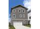 Three-story home with gray siding, white trim, a two-car garage, and a well-manicured lawn at 1415 Coretta Bnd, Atlanta, GA 30318