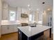 Modern kitchen features white cabinets, stainless steel appliances, and large island with pendant lighting at 1415 Coretta Bnd, Atlanta, GA 30318