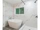 Beautiful bathroom featuring a tub and glass walk-in shower with marble-style tile at 1482 Connally Sw Ave, Atlanta, GA 30310
