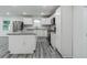 Modern kitchen featuring white cabinets, an island, stainless steel appliances, and wood plank flooring at 1482 Connally Sw Ave, Atlanta, GA 30310