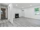 Bright living room with a fireplace, wood plank flooring, and a front door at 1482 Connally Sw Ave, Atlanta, GA 30310