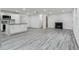 Open-concept living space with a fireplace, wood plank flooring, and a modern kitchen at 1482 Connally Sw Ave, Atlanta, GA 30310