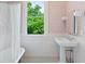 Charming bathroom featuring pink wallpaper, wainscoting, and a pedestal sink for a vintage feel at 872 Euclid Ne Ave, Atlanta, GA 30307