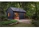 Modern shed with dark exterior, open doors and ample storage, set in a landscaped yard at 872 Euclid Ne Ave, Atlanta, GA 30307
