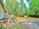 Backyard area with wooden deck, driveway, grass, trees, and storage shed at 148 Boogers Hill Rd, Oxford, GA 30054