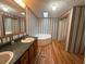 Bathroom with linoleum flooring, garden tub, double sink vanity, and vertical stripe wallpaper at 148 Boogers Hill Rd, Oxford, GA 30054