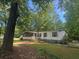Charming single-story home featuring a screened porch, accessible ramp and well-maintained lawn in a wooded, private setting at 148 Boogers Hill Rd, Oxford, GA 30054