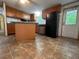 Traditional kitchen features wood cabinets, black appliances, and center island on a tile floor at 148 Boogers Hill Rd, Oxford, GA 30054