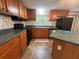 Traditional kitchen features wood cabinets, black appliances, and center island with green countertops at 148 Boogers Hill Rd, Oxford, GA 30054